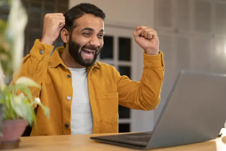 Homme heureux qui vient de gagner de l'argent en ligne en 2025
