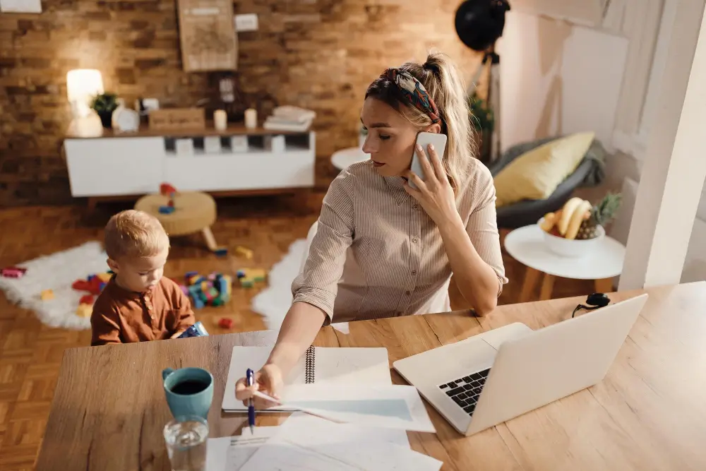 Femme travaillant sur un job à domicile tout en s’occupant de son enfant
